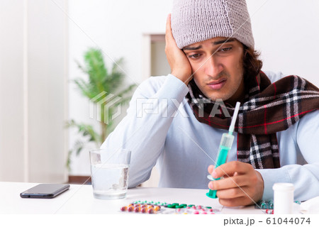 Young man suffering from flu at home 61044074