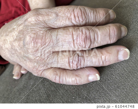 Closeup wrinkled hands of an old woman Closeup wrinkled hands of an old woman 61044748