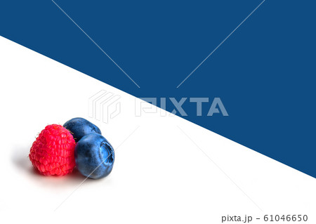 Blueberries and raspberry on white and blue background. 61046650