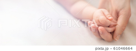 A little baby hand in mothers palm 61046664