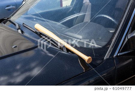 Wooden baseball bat lies on the car Wooden baseball bat lies on the car 61049777