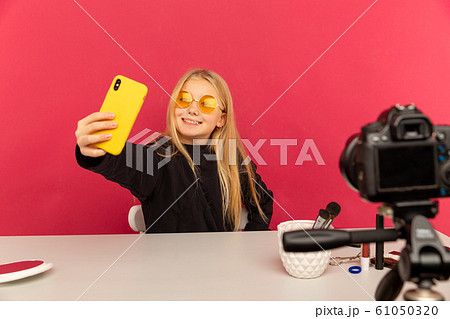 Happy girl at home speaking in front of camera for vlog. Young black woman working as blogger, recording video tutorial for Internet. 61050320