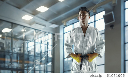 Confident korean man in kimono practicing hand-to-hand combat, martial arts Confident korean man in kimono practicing hand-to-hand combat, martial arts 61051006