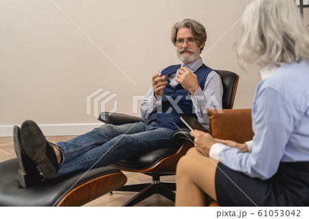 Patient sitting in front of his psychoanalyst 61053042