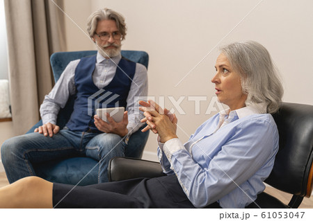 Dejected business lady talking to his psychotherapist Dejected business lady talking to his psychotherapist 61053047