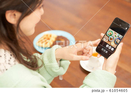 料理の写真を見る女性の手元 料理の写真を見る女性の手元 61054605
