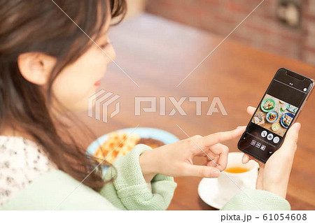 ランチの写真を見る女性の手元 ランチの写真を見る女性の手元 61054608
