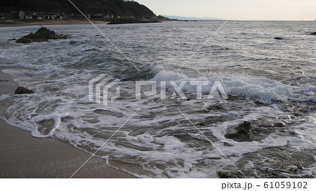 日本海の砂浜と奇岩に打ち寄せる波 61059102