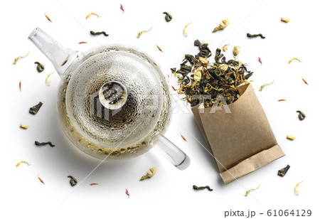 Green tea with natural aromatic additives and a teapot. Top view on white background 61064129