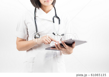 Young asian nurse with a stethoscope using a digital tablet, isolated over white background. Young asian nurse with a stethoscope using a digital tablet, isolated over white background. 61065135