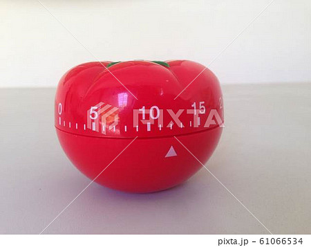 Pomodoro Timer red with green details. Tomato on the table. Vibrant, multi-angle colors. Pomodoro Timer red with green details. Tomato on the table. Vibrant, multi-angle colors. 61066534