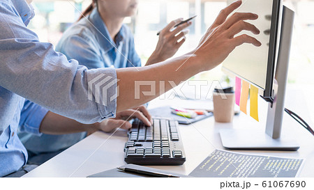 Young startup Programmers Sitting At Desks Working Young startup Programmers Sitting At Desks Working 61067690