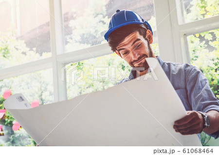 Architect looking at blue print project with a Architect looking at blue print project with a 61068464