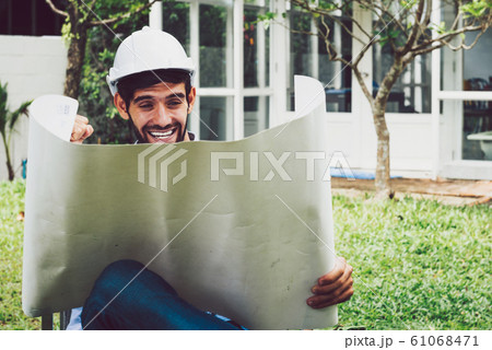 A young architect looking at blueprint, design A young architect looking at blueprint, design 61068471
