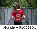 Rear of woman with backpack standing on sky walk in forest	 61068901