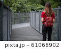 Rear of woman with backpack standing on sky walk in forest	 61068902