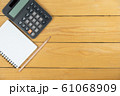 Empty notepad and calculator and pencil on wooden desk, copy space, top view background 61068909
