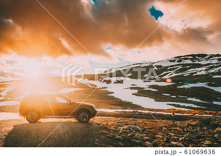 Aurlandsfjellet, Norway. Car SUV Parked Near Aurlandsfjellet Scenic Route Road In Summer Norwegian Landscape. Popular Destination In Sunset Lights Aurlandsfjellet, Norway. Car SUV Parked Near Aurlandsfjellet Scenic Route Road In Summer Norwegian Landscape. Popular Destination In Sunset Lights 61069636