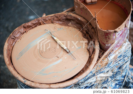 The potter makes pottery dishes on potter's wheel. 61069823