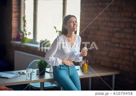 Nice unhappy young woman suffering from stomachache 61070458