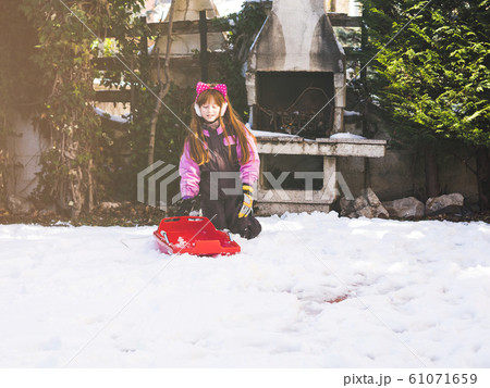 Little redhead girl playing in winter with snow Little redhead girl playing in winter with snow 61071659