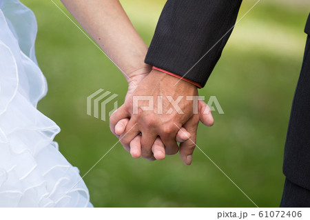 Young married couple holding hands, ceremony Young married couple holding hands, ceremony 61072406