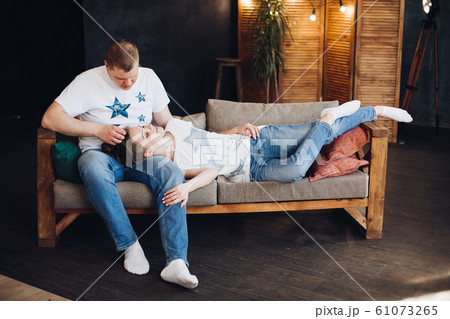 Young couple laying together on belly in bed at 61073265