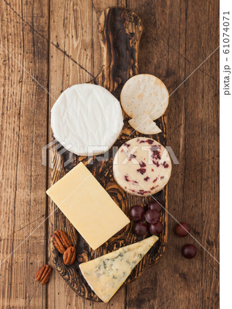 Selection of various cheese on the board on wooden 61074071