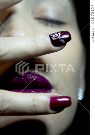 Portrait of woman with hand over face 61075157