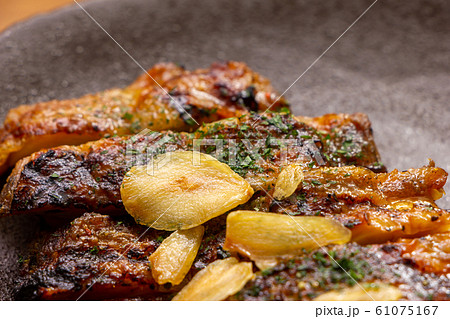 チキンステーキ･グリルチキンにのせられた、ガーリックチップ(にんにくチップ)のアップ。 61075167