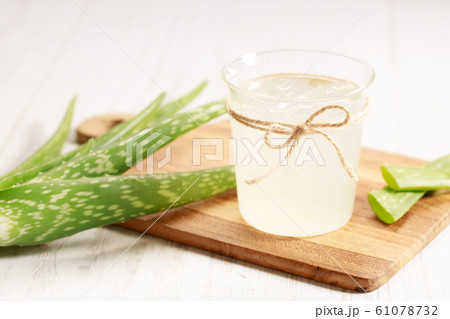 aloe vera juice in a glass on wooden paddle board 61078732