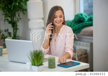 Joyful pretty businesswoman taking her new tablet 61080351