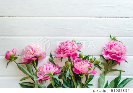 Pink peony flowers on white wooden table. womans day or wedding background. Top view. Pink peony flowers on white wooden table. womans day or wedding background. Top view. 61082334