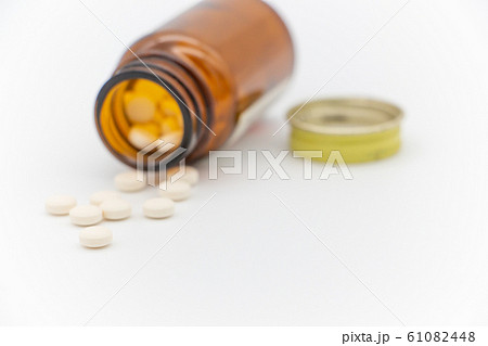 薬が茶色の瓶からこぼれる　病気イメージ 61082448