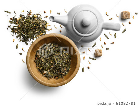 Green tea with natural aromatic additives and a teapot. Top view on white background 61082781
