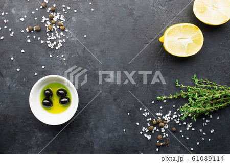 Black food frame background with fresh aromatic herbs and spices, copy space, top view. Allspice, thyme, lemon, olives olives on a dark background Black food frame background with fresh aromatic herbs and spices, copy space, top view. Allspice, thyme, lemon, olives olives on a dark background 61089114