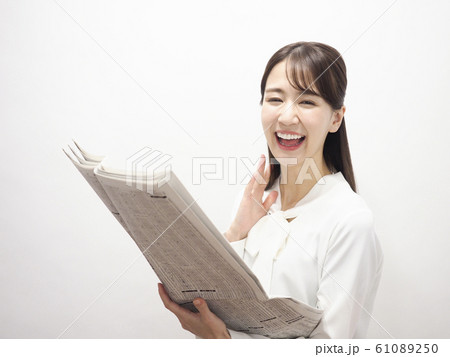 新聞の株式欄を見て微笑むビジネスウーマン 61089250