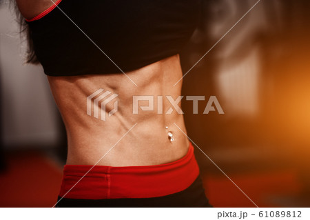 Sporty girl in gym show abs. woman in tonus 61089812