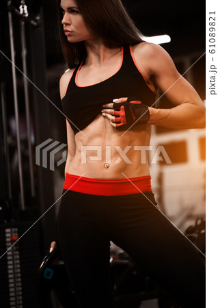 Sporty girl in gym doing exercises and show abs Sporty girl in gym doing exercises and show abs 61089821