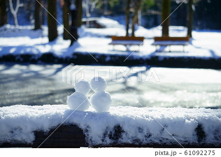 雪景色に佇むゆきだるまカップル 61092275