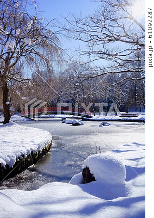 池の水が凍りそうな雪国の冬の公園 61092287