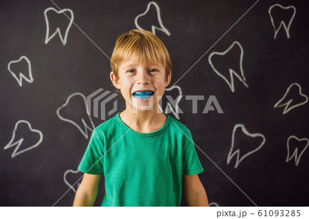 Six-year old boy shows myofunctional trainer. Helps equalize the growing teeth and correct bite Six-year old boy shows myofunctional trainer. Helps equalize the growing teeth and correct bite 61093285