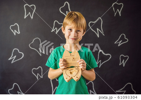 A boy, 6 years old, holds a box for milk teeth. Change of teeth A boy, 6 years old, holds a box for milk teeth. Change of teeth 61093304