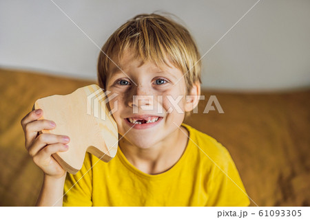 A boy, 6 years old, holds a box for milk teeth. Change of teeth 61093305