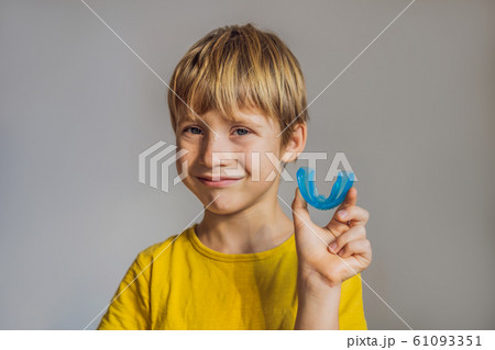Six-year old boy shows myofunctional trainer. Helps equalize the growing teeth and correct bite 61093351