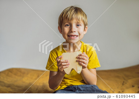 A boy, 6 years old, holds a box for milk teeth. Change of teeth 61093445