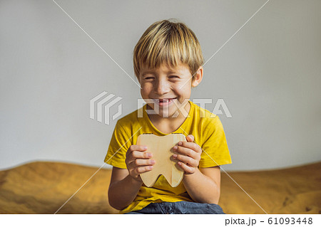 A boy, 6 years old, holds a box for milk teeth. Change of teeth 61093448