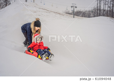 mom son ride on an inflatable winter sled tubing. Winter fun for the whole family mom son ride on an inflatable winter sled tubing. Winter fun for the whole family 61094048