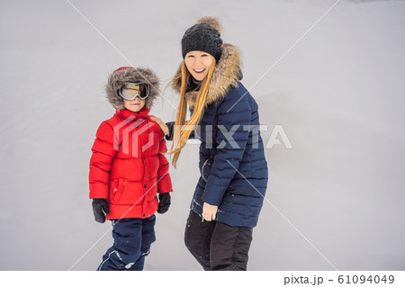 Mom puts on ski glasses for her son Mom puts on ski glasses for her son 61094049