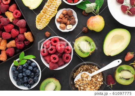 Ingredients for a healthy breakfast. Nutrition, granola, oatmeal, nuts, fruits, berries, kiwi, bananas, raspberries, blueberries, seeds, apples. A diet rich in vitamins and fiber. Top view 61097775